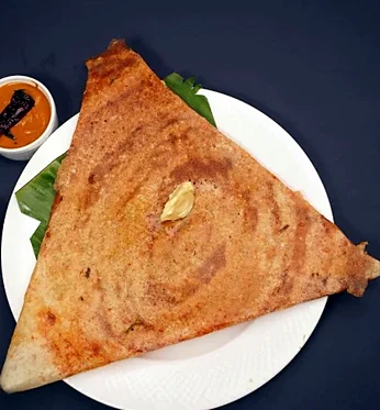 Mysore masala dosa folded into a triangle, with sambar and chutneys